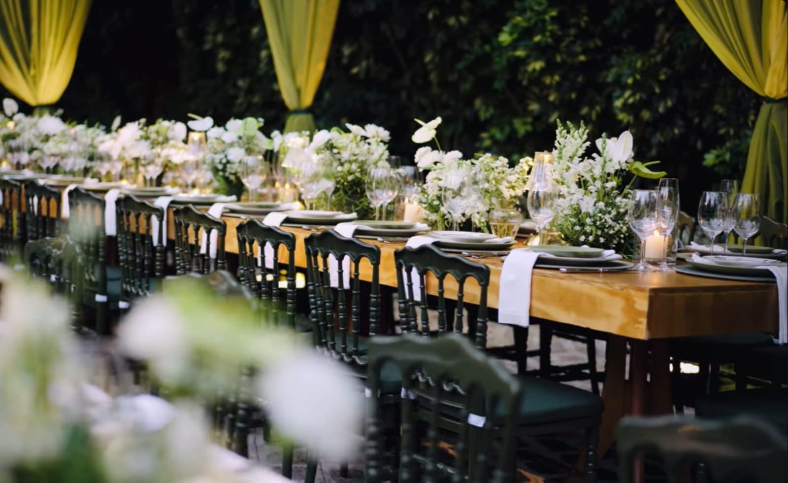 Mesas decoradas em verde e branco em evento ao ar livre